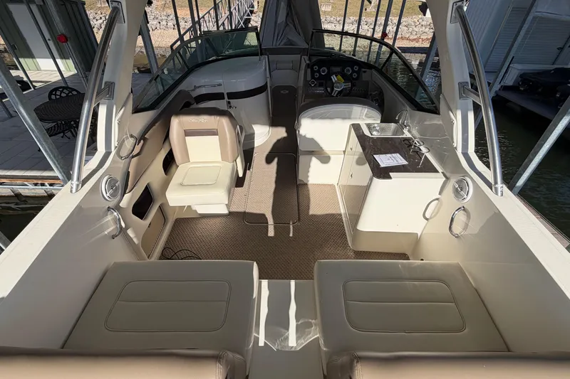 Slide: The Image of 2013 Sea Ray 300 SLX boat interior with seating and helm, docked at marina. - 11