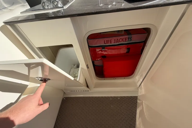 Slide: The Image of 2013 Sea Ray 300 SLX boat interior with life jackets and storage compartments. - 16