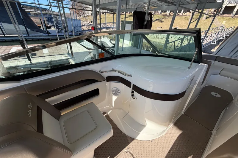 Slide: The Image of 2013 Sea Ray 300 SLX boat interior with seating and dashboard in a marina setting. - 19