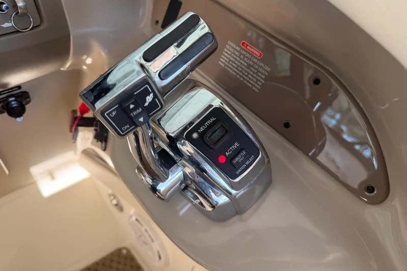 Slide: The Image of Close-up of 2013 Sea Ray 300 SLX boat throttle controls with trim and neutral settings. - 26