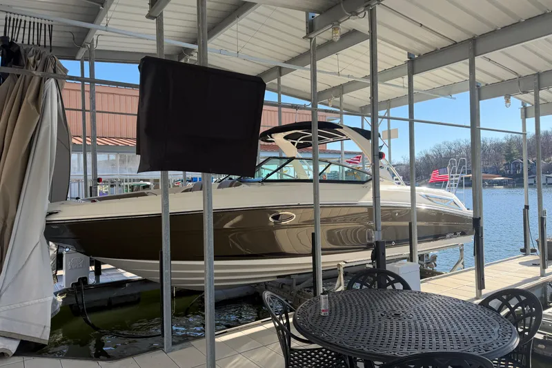 Slide: The Image of 2013 Sea Ray 300 SLX boat docked under a covered marina with lake view. - 3