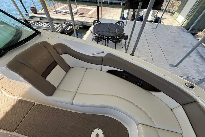 Slide: The Image of 2013 Sea Ray 300 SLX boat interior with cushioned seating, dockside view. - 32