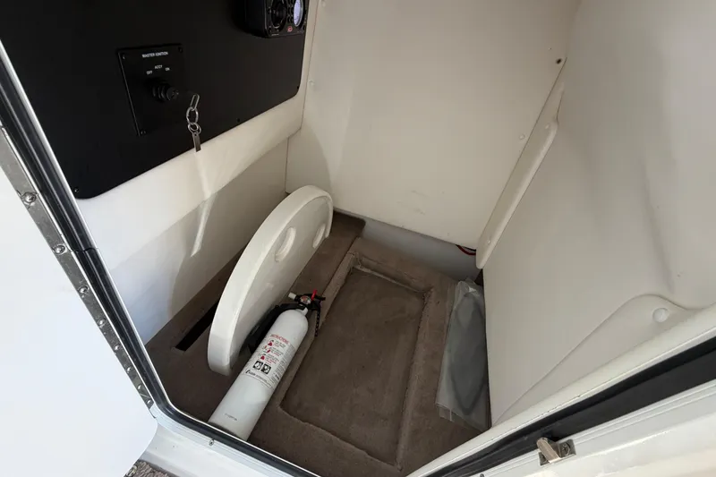Slide: The Image of 2013 Sea Ray 300 SLX interior storage with fire extinguisher and control panel. - 36