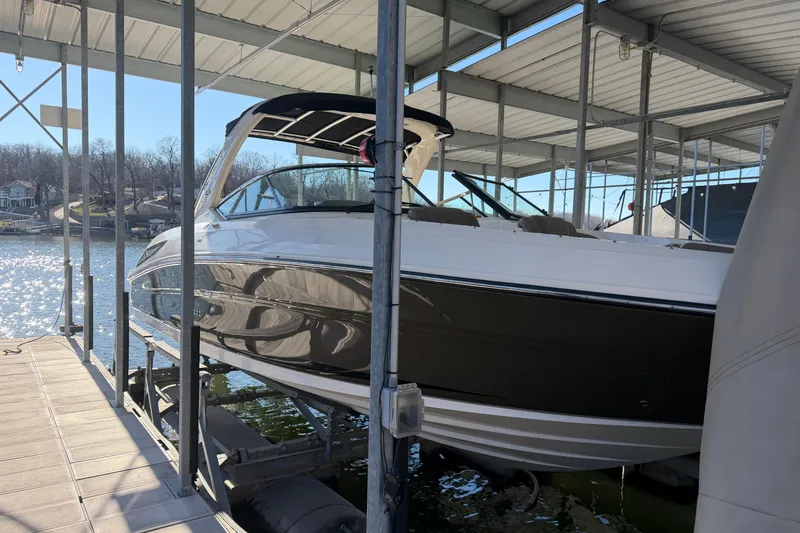 Slide: The Image of 2013 Sea Ray 300 SLX boat docked in a covered marina, reflecting sunlight on water. - 8