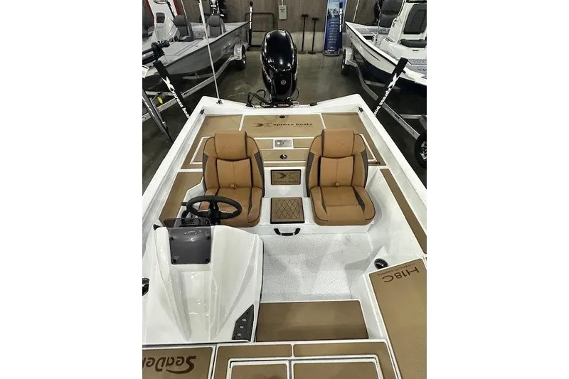 Slide: The Image of 2026 Xpress H18C Crappie boat interior with tan seats and steering console. - 5