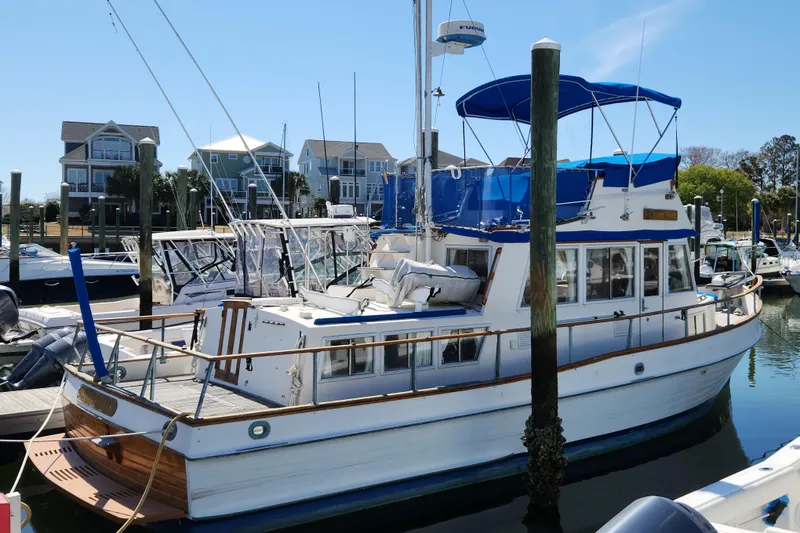 The Image of 1983 Grand Banks 36 Classic yacht docked at a marina with waterfront homes. - 0