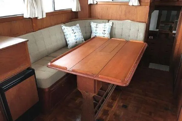 Slide: The Image of 1983 Grand Banks 36 Classic interior with wooden table and cushioned seating. - 11