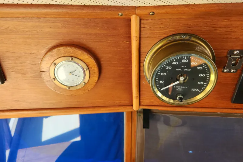 Slide: The Image of Wooden dashboard with clock and wind speed gauge on 1983 Grand Banks 36 Classic boat. - 18