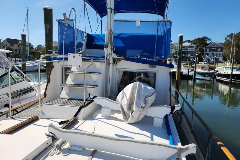 Slide: The Image of 1983 Grand Banks 36 Classic yacht docked at marina, featuring blue canopy and white deck. - 2