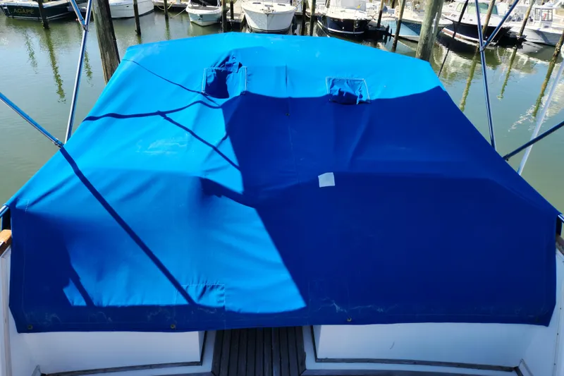 Slide: The Image of 1983 Grand Banks 36 Classic with blue cover at marina. - 33