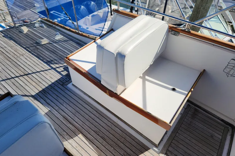 Slide: The Image of 1983 Grand Banks 36 Classic boat deck with white seating and wooden trim. - 38
