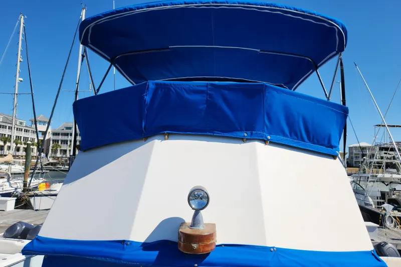 Slide: The Image of 1983 Grand Banks 36 Classic boat with blue canopy in marina. - 39
