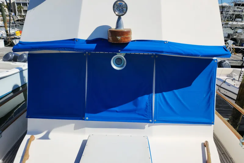 Slide: The Image of 1983 Grand Banks 36 Classic yacht with blue canvas cover in marina. - 40
