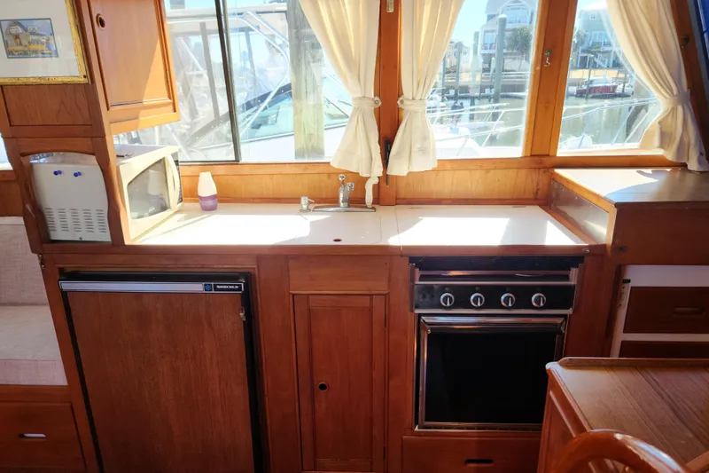 Slide: The Image of 1983 Grand Banks 36 Classic yacht kitchen with stove, fridge, and microwave. - 9