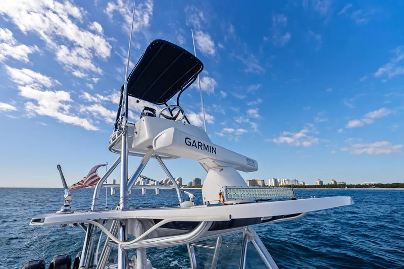 Slide: The Image of 2013 Invincible 42 Open Fisherman boat on ocean, clear sky, city skyline in background. - 43