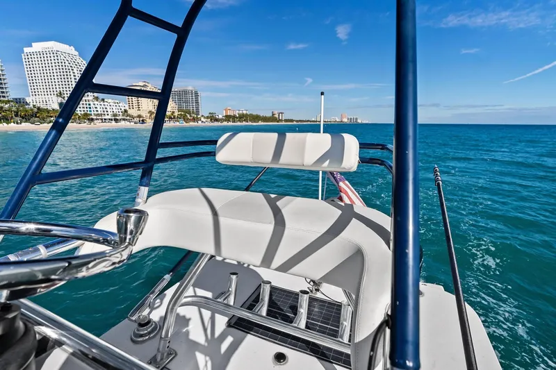 Slide: The Image of 2013 Invincible 42 Open Fisherman boat cruising near a coastal city skyline. - 44