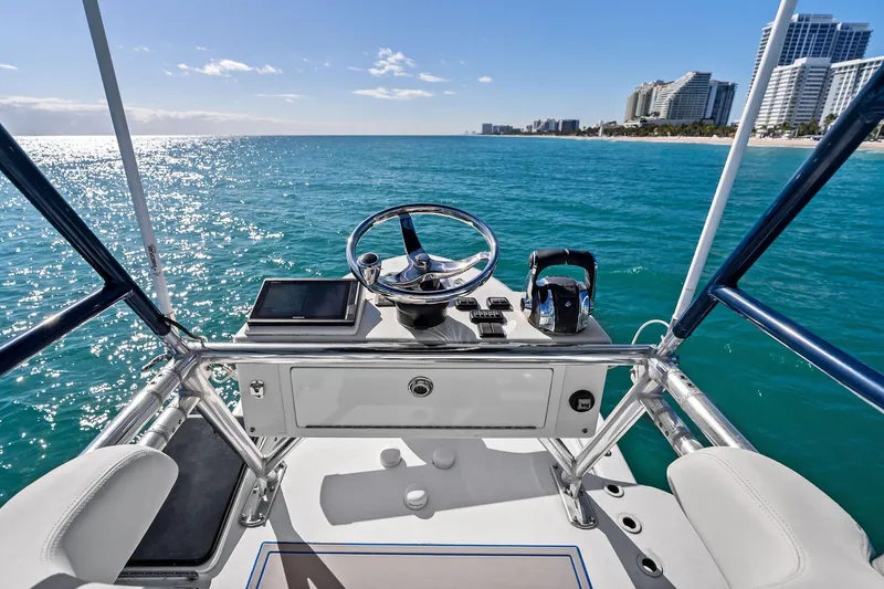 Slide: The Image of Helm of 2013 Invincible 42 Open Fisherman on clear blue ocean near city skyline. - 45