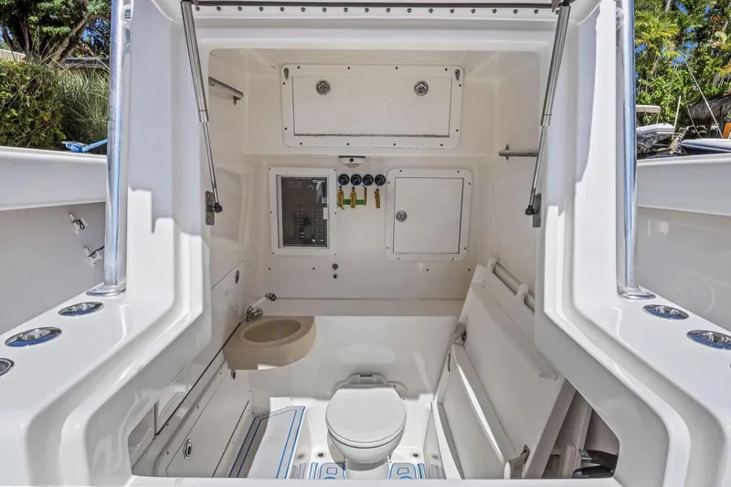 Slide: The Image of Interior of 2013 Invincible 42 Open Fisherman boat, featuring a compact bathroom area. - 46