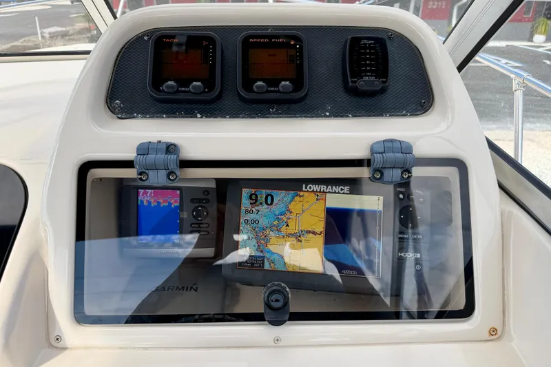 Slide: The Image of 2006 Grady-White Adventure 208 boat dashboard with navigation and control instruments. - 14