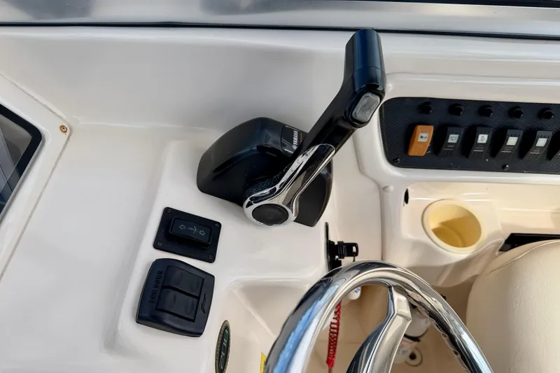 Slide: The Image of 2006 Grady-White Adventure 208 boat control panel with steering wheel and throttle lever. - 18