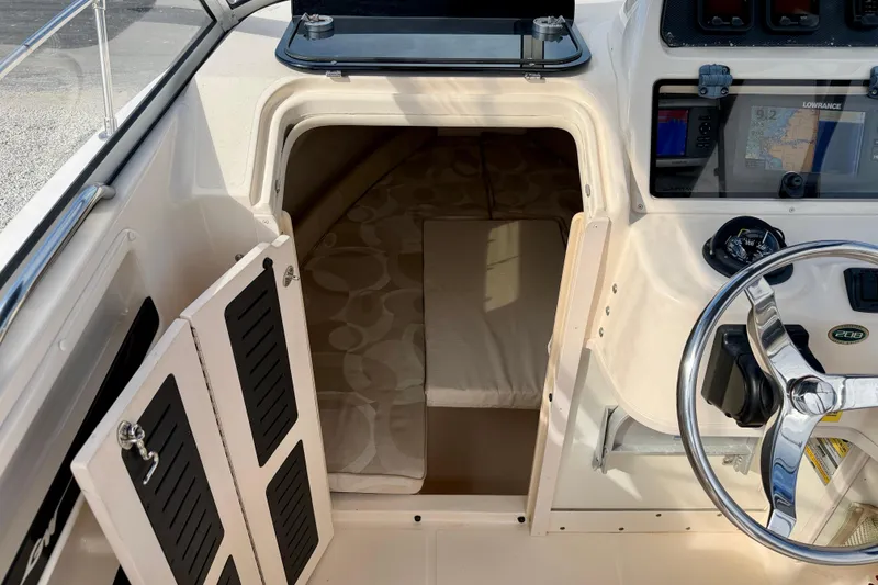 Slide: The Image of 2006 Grady-White Adventure 208 boat cabin interior with steering wheel and navigation system. - 23
