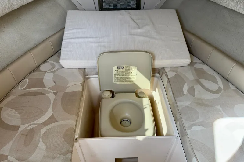 Slide: The Image of 2006 Grady-White Adventure 208 cabin interior with portable toilet and cushioned seating. - 26