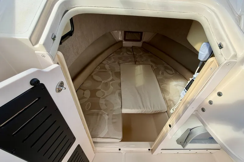 Slide: The Image of 2006 Grady-White Adventure 208 cabin interior with cushioned seating and storage. - 27