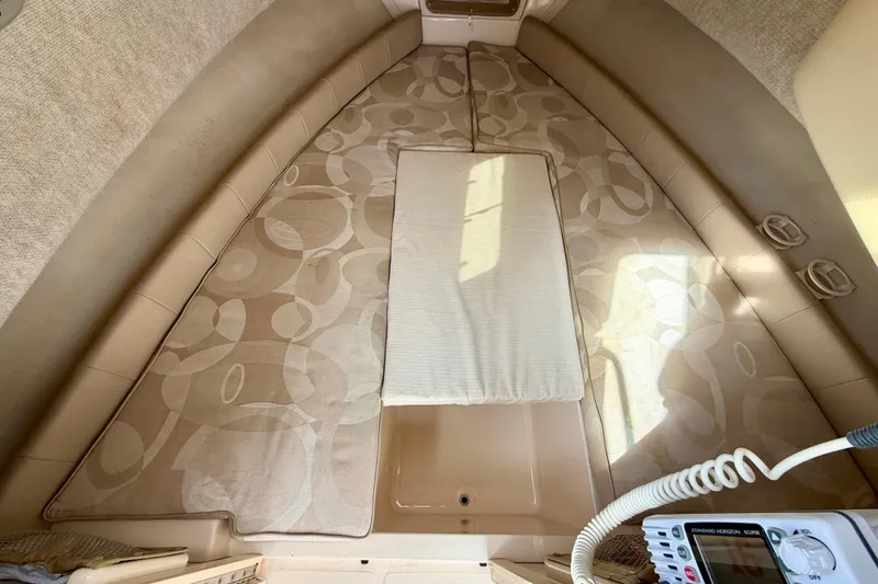 Slide: The Image of 2006 Grady-White Adventure 208 cabin interior with patterned cushions and marine radio. - 28