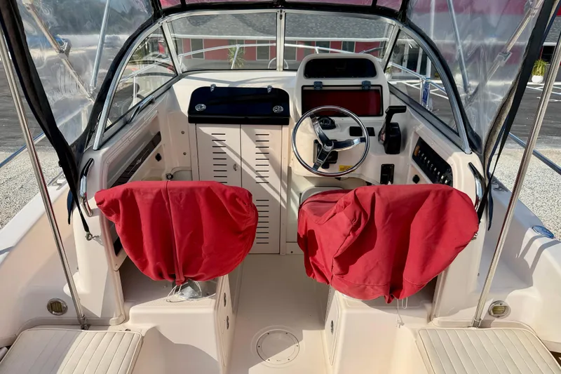 Slide: The Image of 2006 Grady-White Adventure 208 boat interior with red-covered seats and steering console. - 34