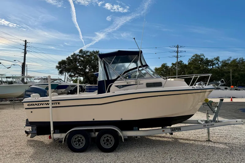Slide: The Image of 2006 Grady-White Adventure 208 boat on trailer, parked outdoors under blue sky. - 4