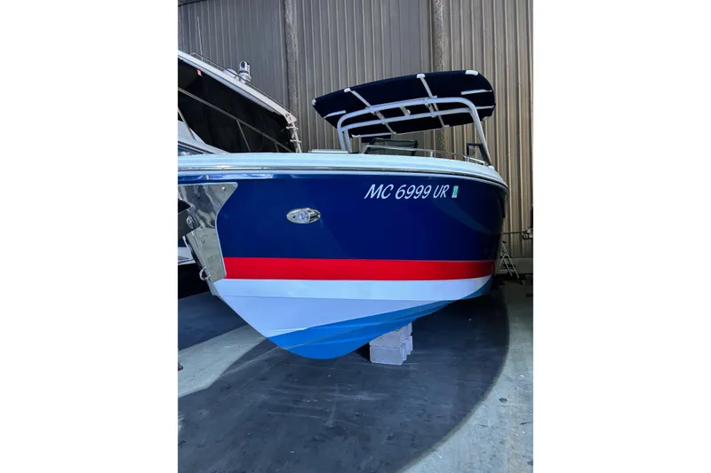 Slide: The Image of 2021 Cobalt A29 boat with blue, red, and white hull in storage. - 5