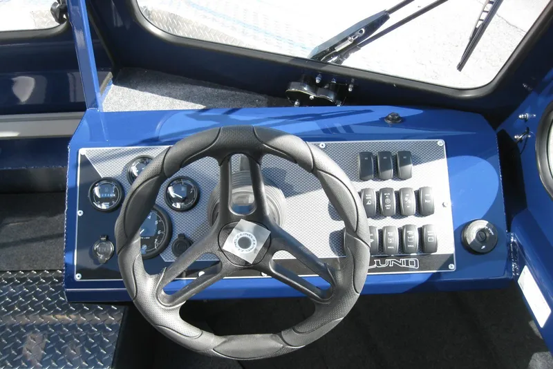 Slide: The Image of 2026 Lund 185 Heavy Gauge boat interior with steering wheel and control panel. - 19