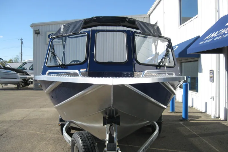 Slide: The Image of 2026 Lund 185 Heavy Gauge boat on trailer outside dealership. - 2