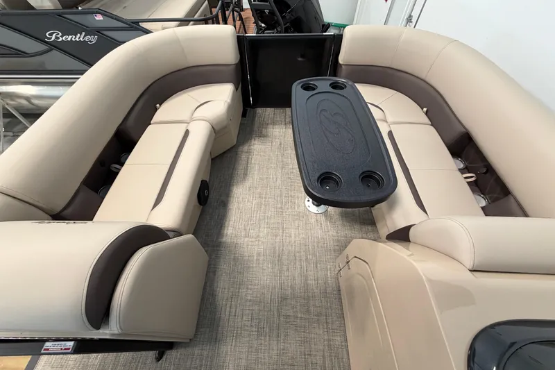 Slide: The Image of 2026 Bentley Pontoons Legacy 223 Swingback interior with beige seating and central table. - 16