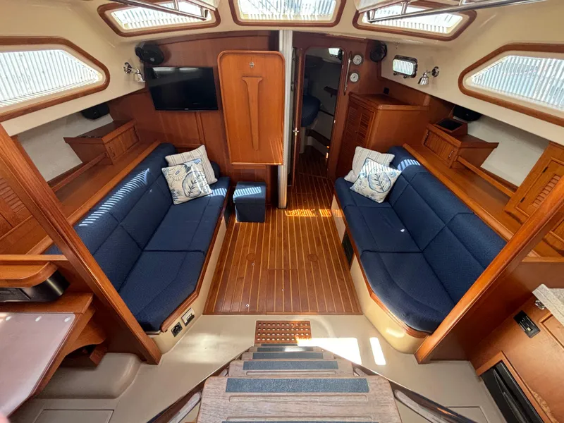 Slide: The Image of Interior of a 2005 Island Packet 445 yacht with blue sofas and wooden flooring. - 3
