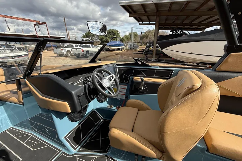 Slide: The Image of 2023 ATX boat interior with tan seats and modern dashboard under cloudy sky. - 10