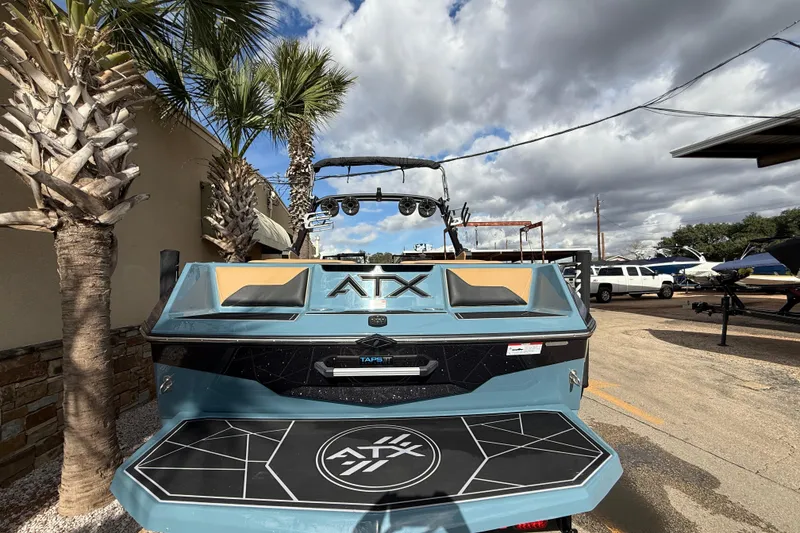 Slide: The Image of 2023 ATX boat with sleek design, parked outdoors under cloudy sky. - 6
