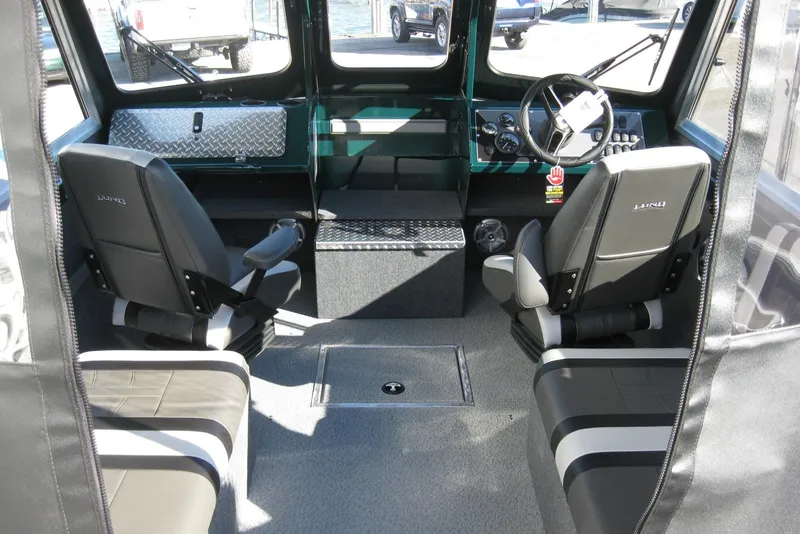 Slide: The Image of 2026 Lund 200 Heavy Gauge boat with open storage compartment and Mercury Pro Kicker engine. - 14