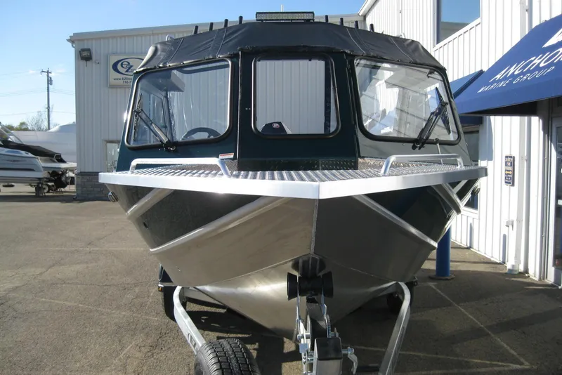 Slide: The Image of 2026 Lund 200 Heavy Gauge boat on trailer, parked outside a building. - 2