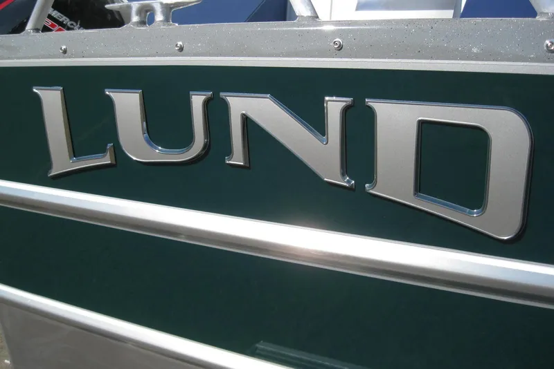 Slide: The Image of Close-up of 2026 Lund 200 Heavy Gauge boat model logo on green surface. - 4