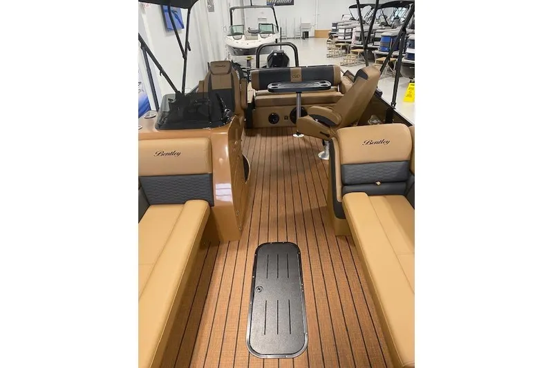 Slide: The Image of 2026 Bentley Pontoons Elite 253 Swingback interior with tan seating and wood-style flooring. - 14