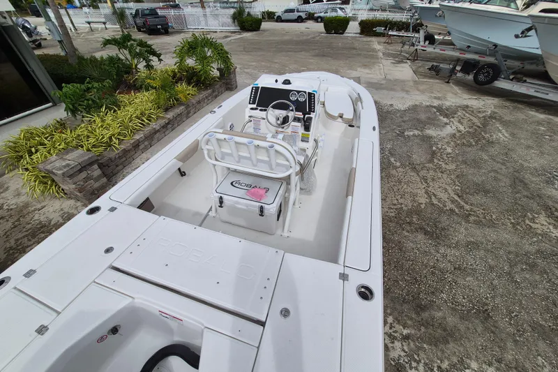Slide: The Image of 2026 Robalo 226 Cayman boat interior with steering console and seating, docked outdoors. - 3