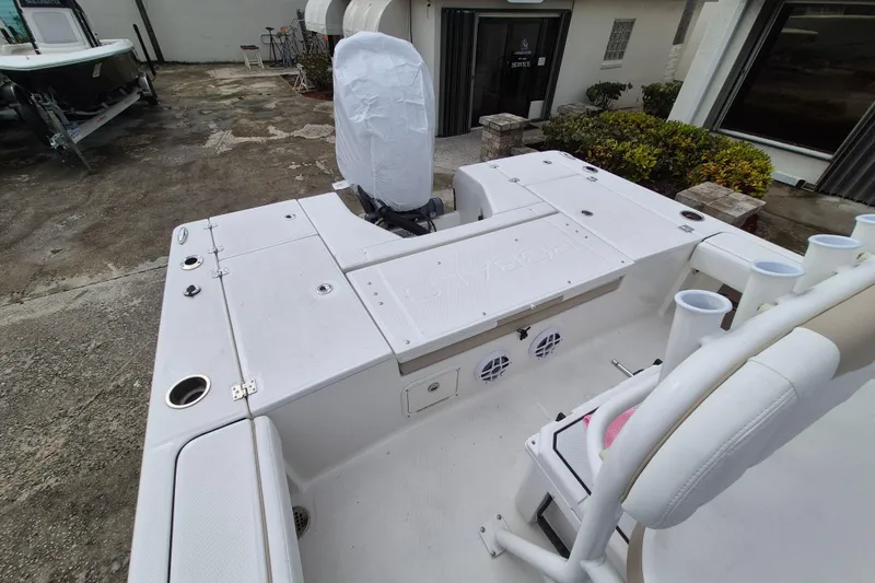 Slide: The Image of 2026 Robalo 226 Cayman boat interior with covered engine, rod holders, and seating. - 9