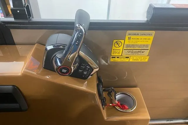 Slide: The Image of Control panel of 2026 Bentley Pontoons Elite 253 Swingback with throttle and warning labels. - 7