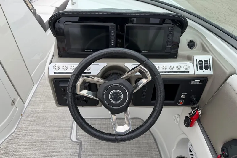 Slide: The Image of 2023 Crownline 280 SS boat dashboard with steering wheel and dual Garmin displays. - 12