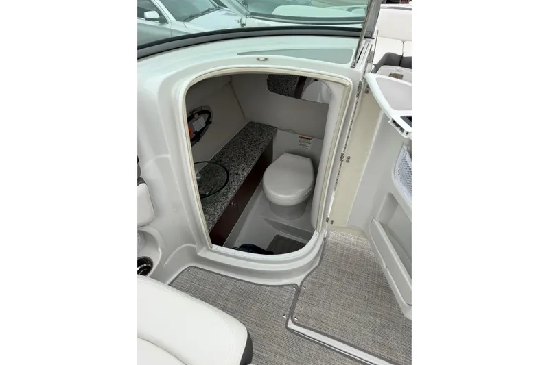 Slide: The Image of 2023 Crownline 280 SS boat interior with compact bathroom and toilet. - 17
