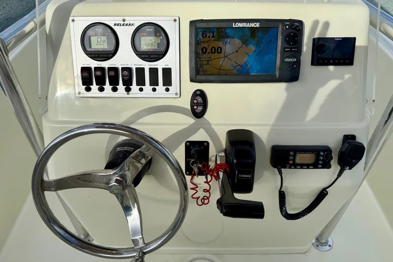 Slide: The Image of Boat dashboard with steering wheel, gauges, Lowrance GPS, and communication devices, Release 180 CC, 2016 model. - 11