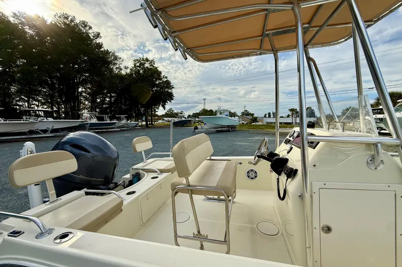 Slide: The Image of 2016 Release 180 CC boat interior with seating and steering console, parked outdoors. - 12