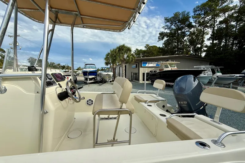 Slide: The Image of 2016 Release 180 CC boat interior with Yamaha 115 engine, parked outdoors. - 13