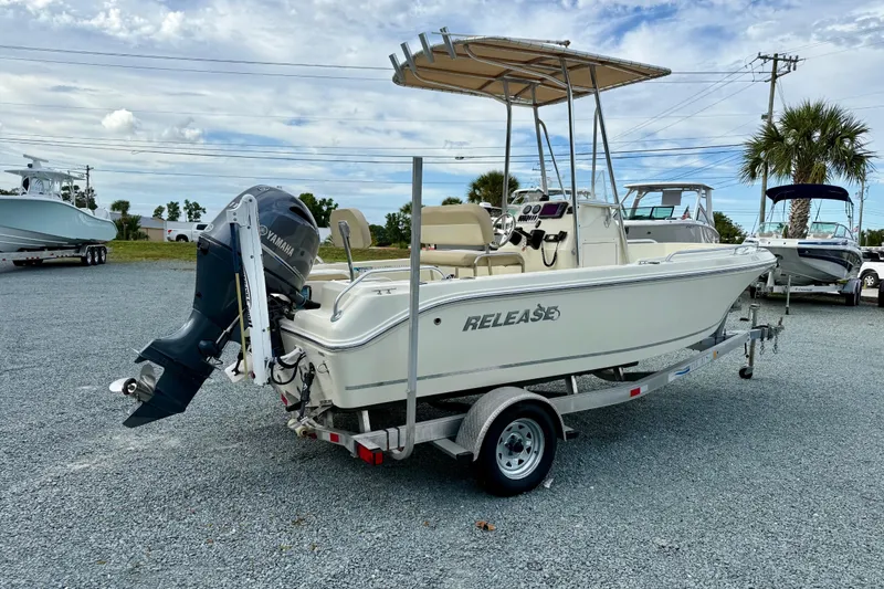 Slide: The Image of 2016 Release 180 CC boat on trailer with Yamaha outboard motor, parked outdoors. - 2